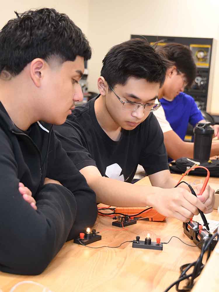 electrical tech students working together to wire a project